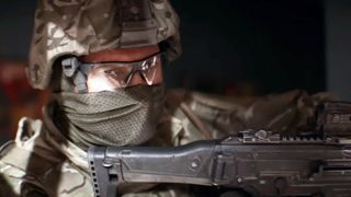 Battlefield 6 ui redesigns: A close-up shot of a soldier wearing full headgear turning to look at the camera while holding their gun up.