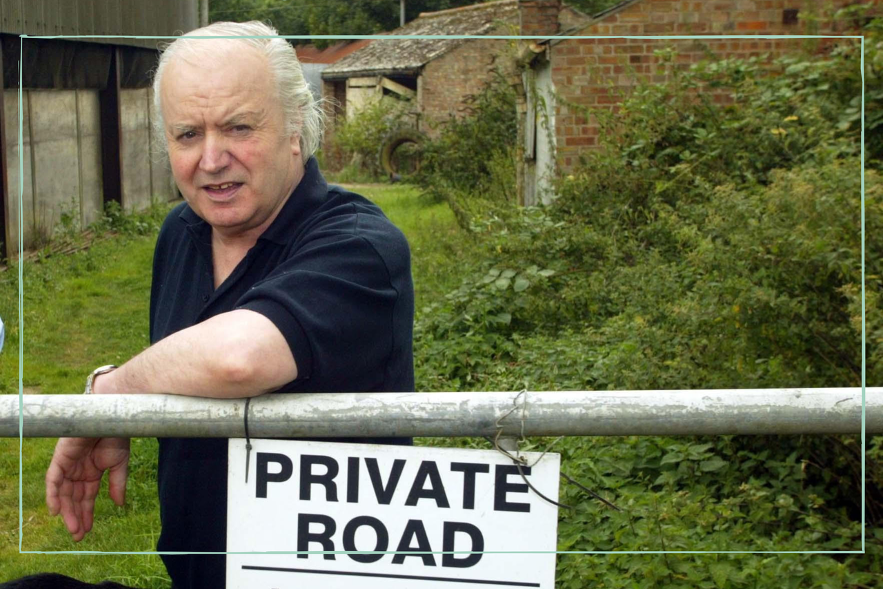 Tony Martin leaning on a fence with a &#039;Privat Road&#039; sign attached to it