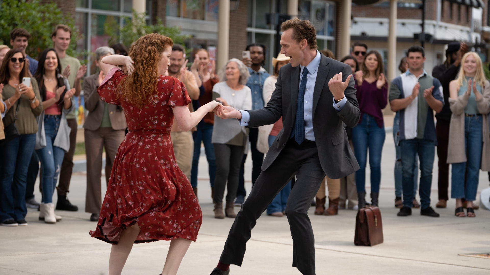 A woman (Annalise Basso) and a man (Tom Hiddleston) dance together in front of a crowd, in 'The Life of Chuck.'