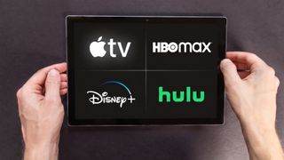(Clockwise from top right) Apple TV, HBO Max, Hulu and Disney Plus logos on a tablet
