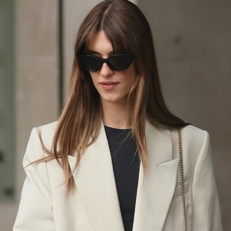 Daisy Edgar-Jones wearing a cream blazer with matching Bermuda shorts and snakeskin sandals.