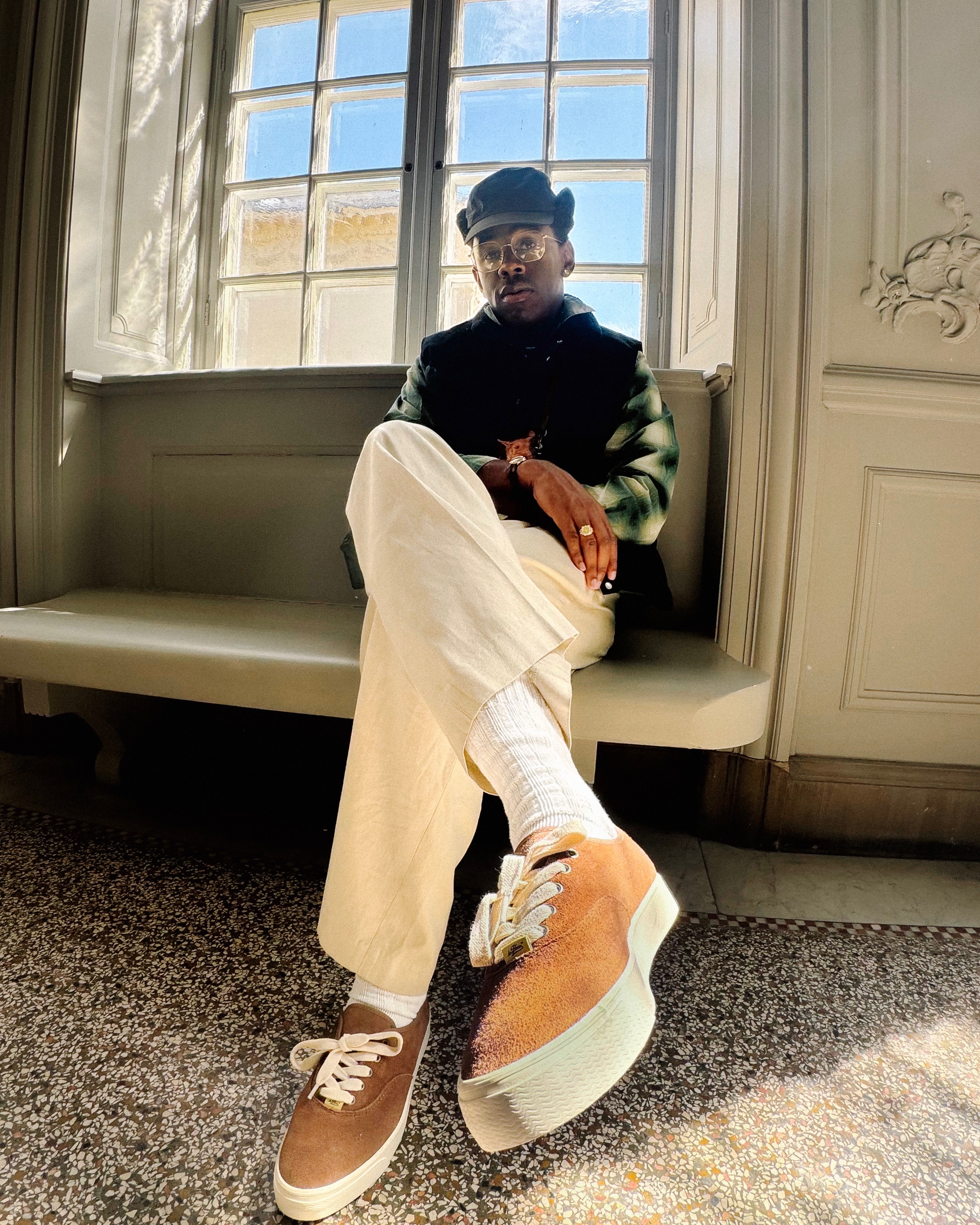 Tyler the Creator wears black top, white pants, and Converse Naut-1 boat shoes.