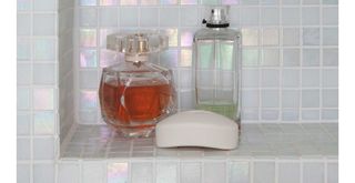 Alcove shower shelf with iridescent tiles to show how to make a bathroom look expensive