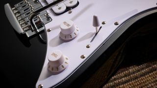 Sterling By Music Man Intro Series Cutlass: the entry-level double-cut electric is finished in gloss black, has a three-ply white pickguard and a maple fingerboard with black dot inlays.