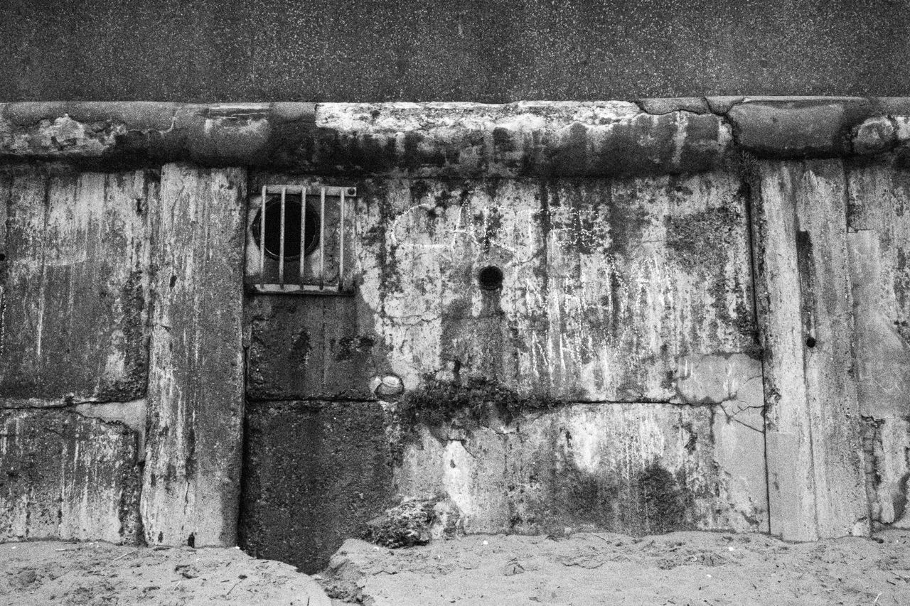 Canon PowerShot V1 black and white photo of stained concrete on a beach