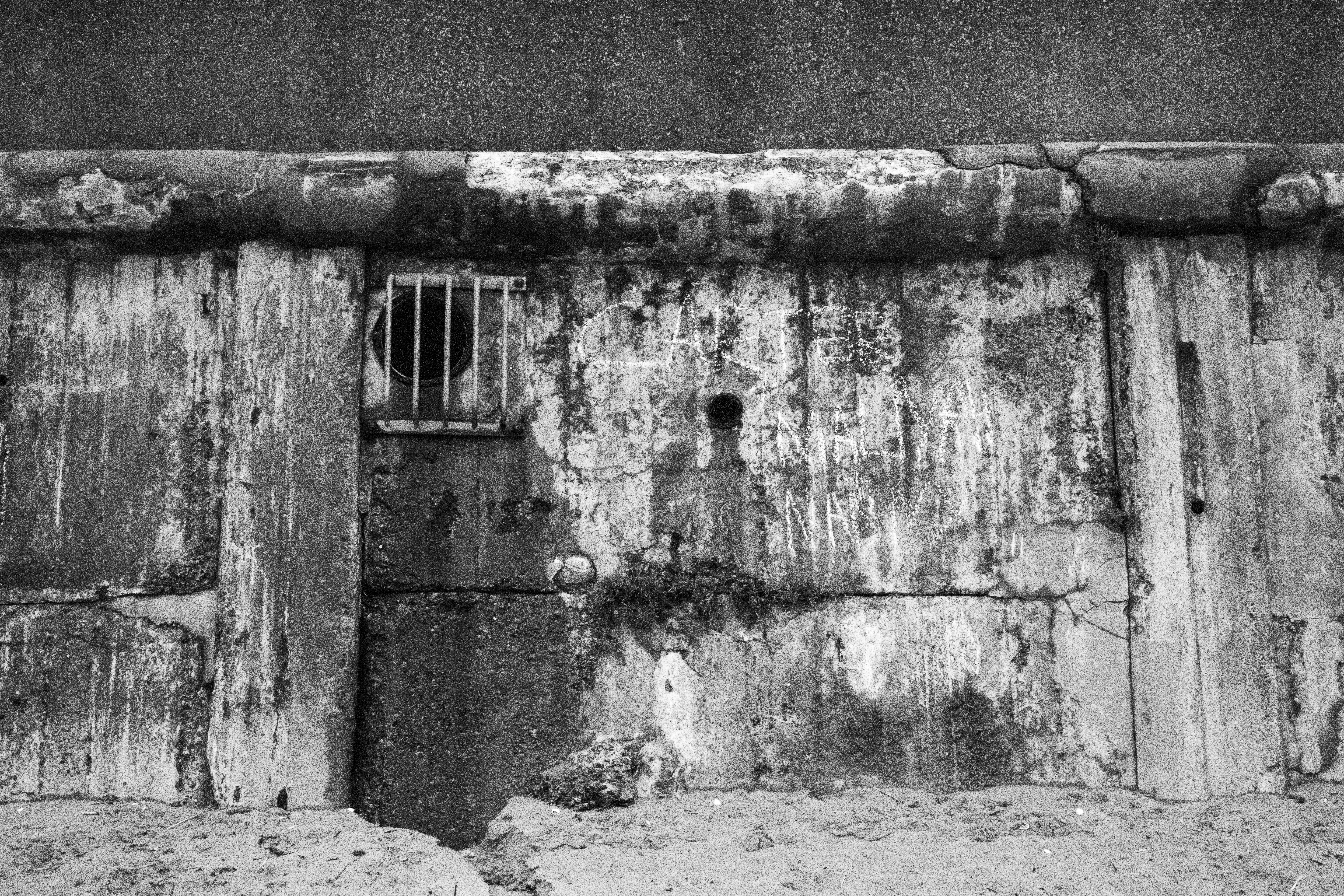 Canon PowerShot V1 black and white photo of stained concrete on a beach