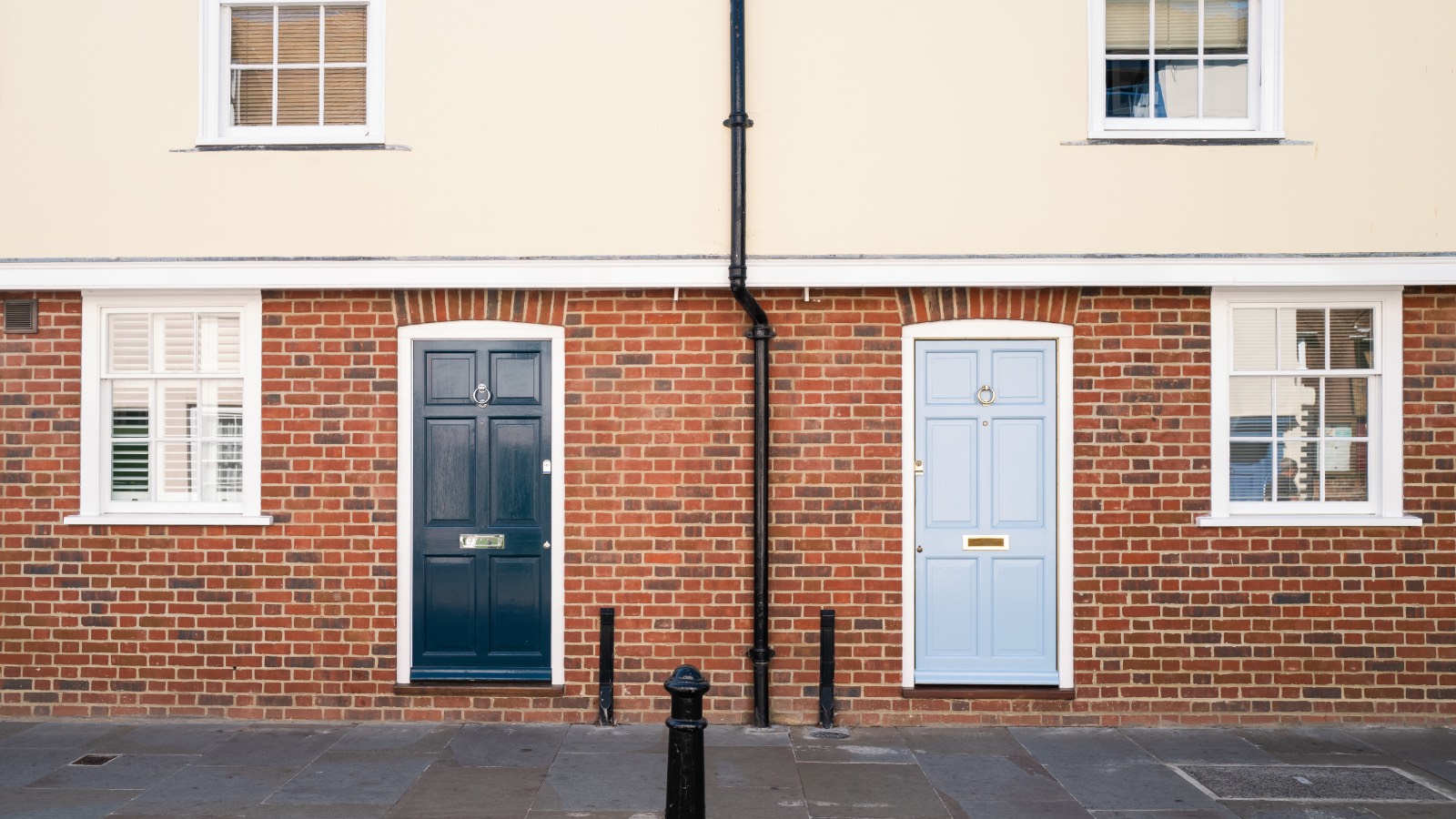 Two houses directly on pavement with drainpipe between