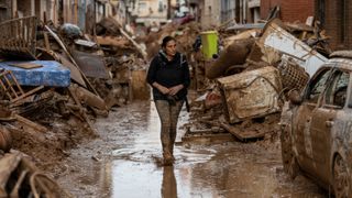  A woman walks along a street full of mud and waste from houses after heavy rain and flooding hit large parts of the country on November 02, 2024 in Paiporta municipality, in Valencia, Spain. 