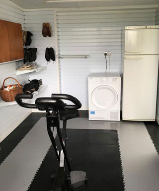 A garage home gym with washing machine and fridge