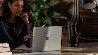 Woman using Surface Book 3 next to a plant