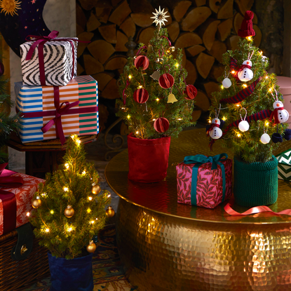 mini christmas trees on gold table in festive living room