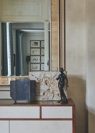 A bronze statue and slab on a sideboard