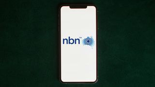 NBN logo on phone on dark green background