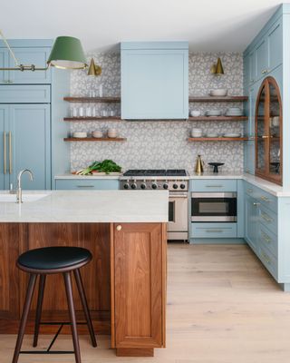 a light blue kitchen with a patterned backsplash