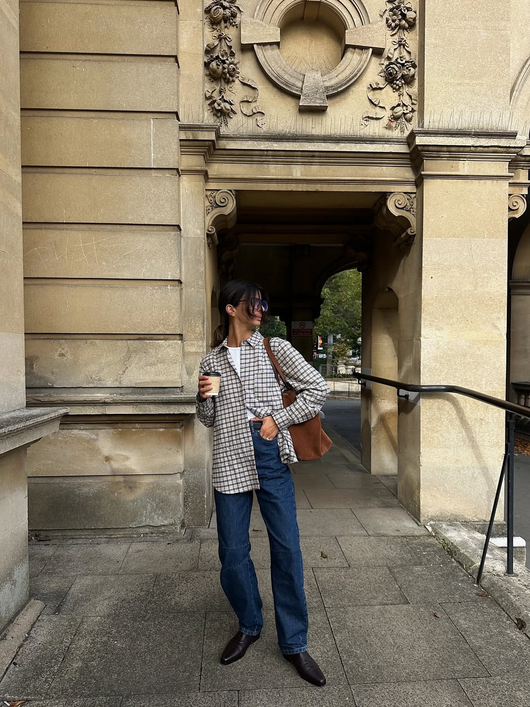 Influencer Santina Harrison wearing a flannel shirt, straight-leg jeans and pointed boots.