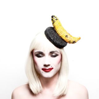A lady is having fruits on head.