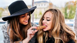 nutritionist debunks 6 common dieting myths: two women snacking on a granola bar