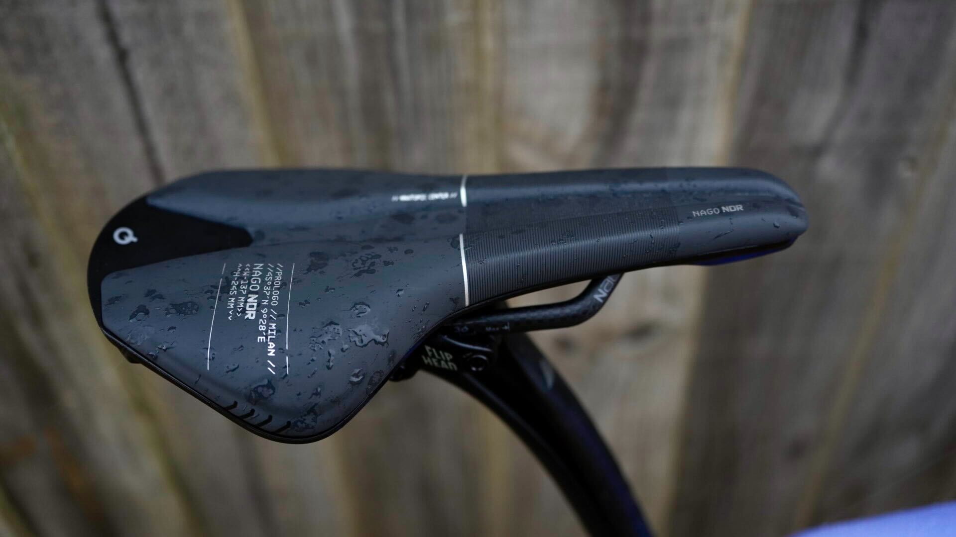 Gravel bike with prologo NDR saddle against a wooden fence