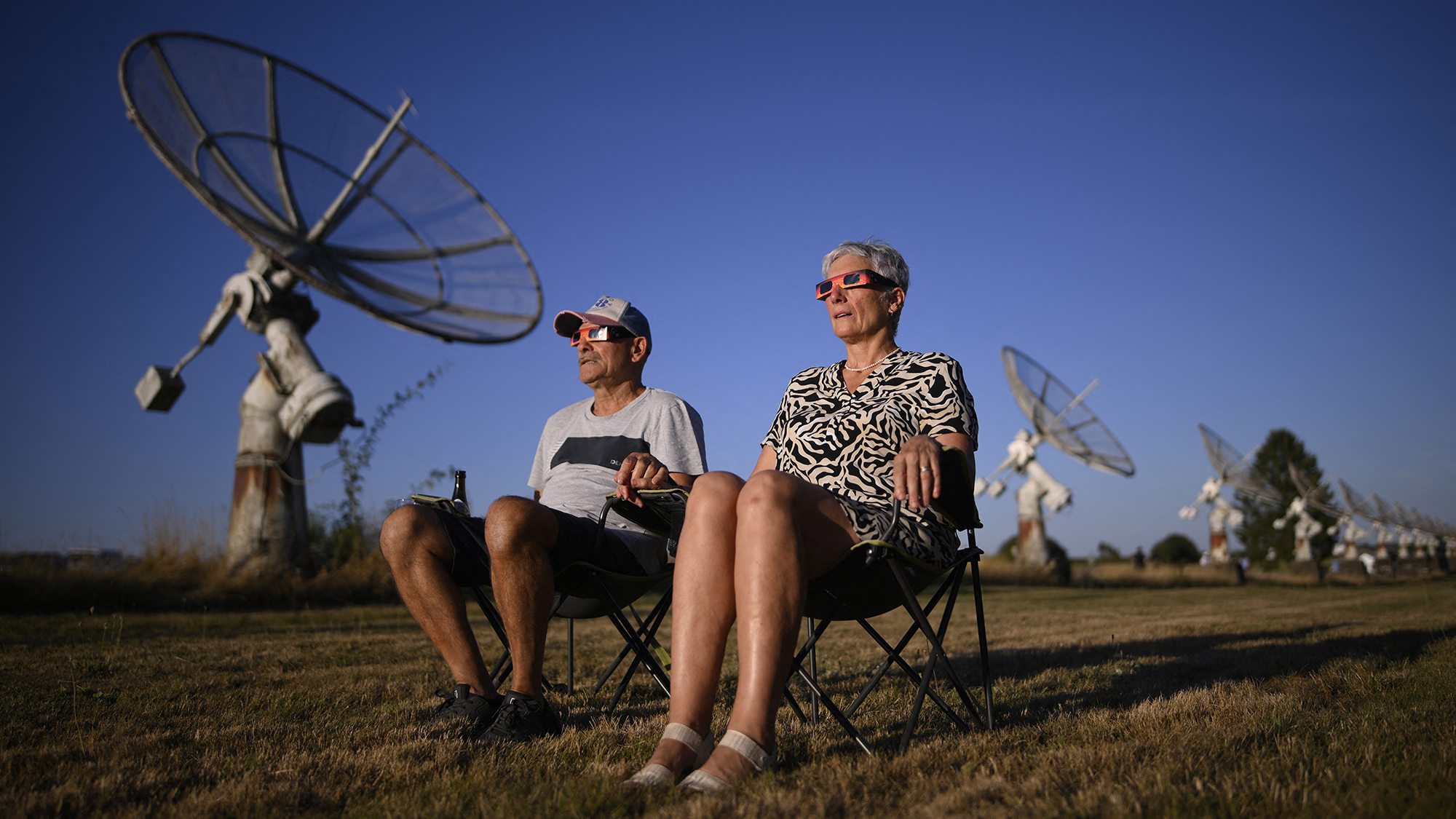 A couple hold hands while watching the partial solar eclipse at the Royal Observatory of Belgium in Marche-en-Famenne, Belgium