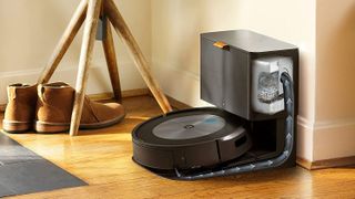 iRobot Roomba j7+ on wooden floor next to shoes