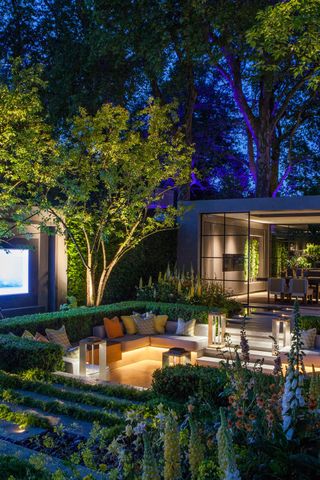 modern garden ideas with outdoor cinema, sunken seating and uplighters