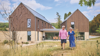Couple standing in front of wood-cladded house