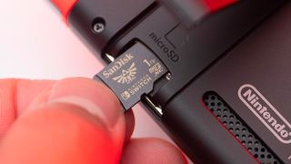 Nintendo Switch Cyber Monday live blog; fingers push a memory stick into a Switch