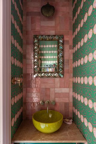 Colorful bathroom with pink tiles and green wallpaper Barlow & Barlow