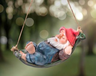 gnome in a swing with a red hat