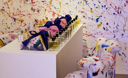 Perfume display in room with Jackson Pollack-inspired walls and chairs