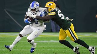 Jamaal Williams #30 of the Detroit Lions is tackled by Krys Barnes #51 of the Green Bay Packers during the second half at Lambeau Field on Sept. 20, 2021 in Green Bay, Wisconsin.