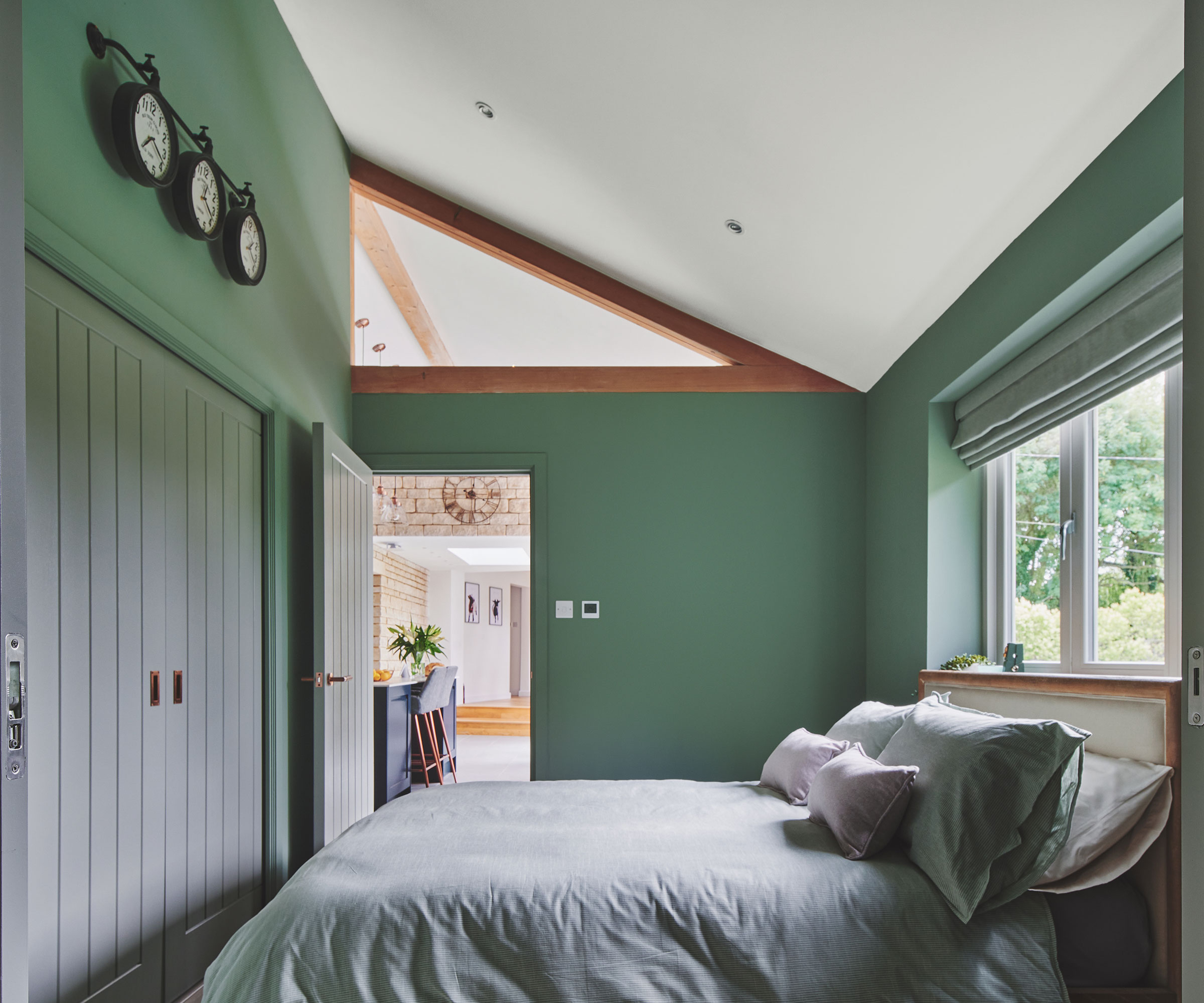 small green bedroom with bed under window