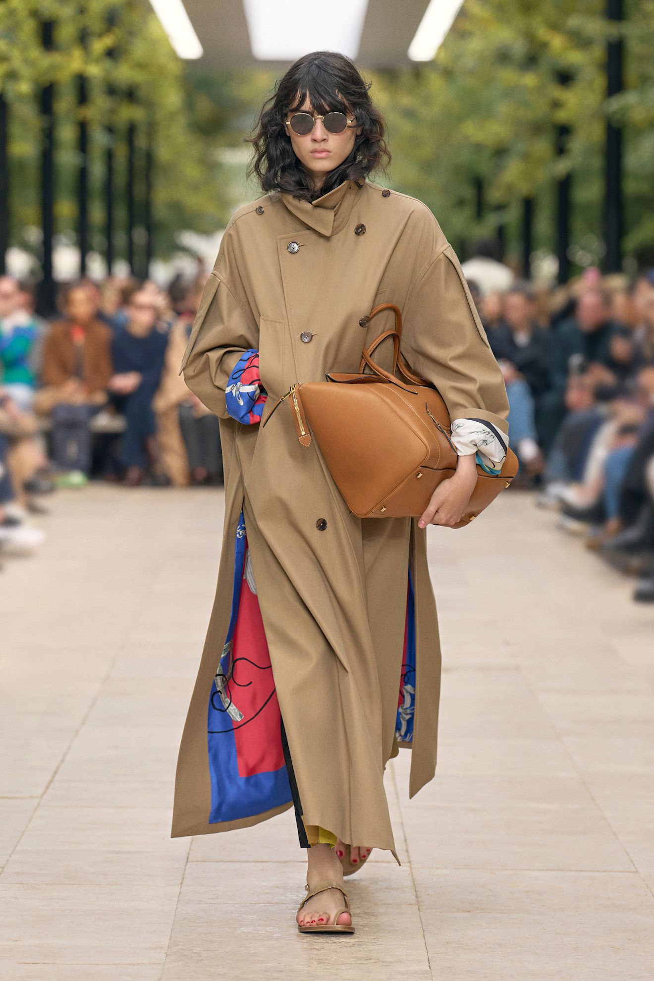 A model at the spring/summer 2026 show for Celine wearing a floor-length trench coat with sandals.