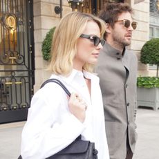 Margot Robbie wearing a white button-down, light-wash jeans, and black pumps, leaving The Ritz in Paris