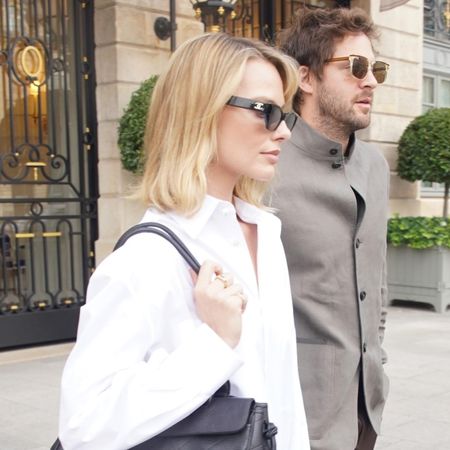 Margot Robbie wearing a white button-down, light-wash jeans, and black pumps, leaving The Ritz in Paris