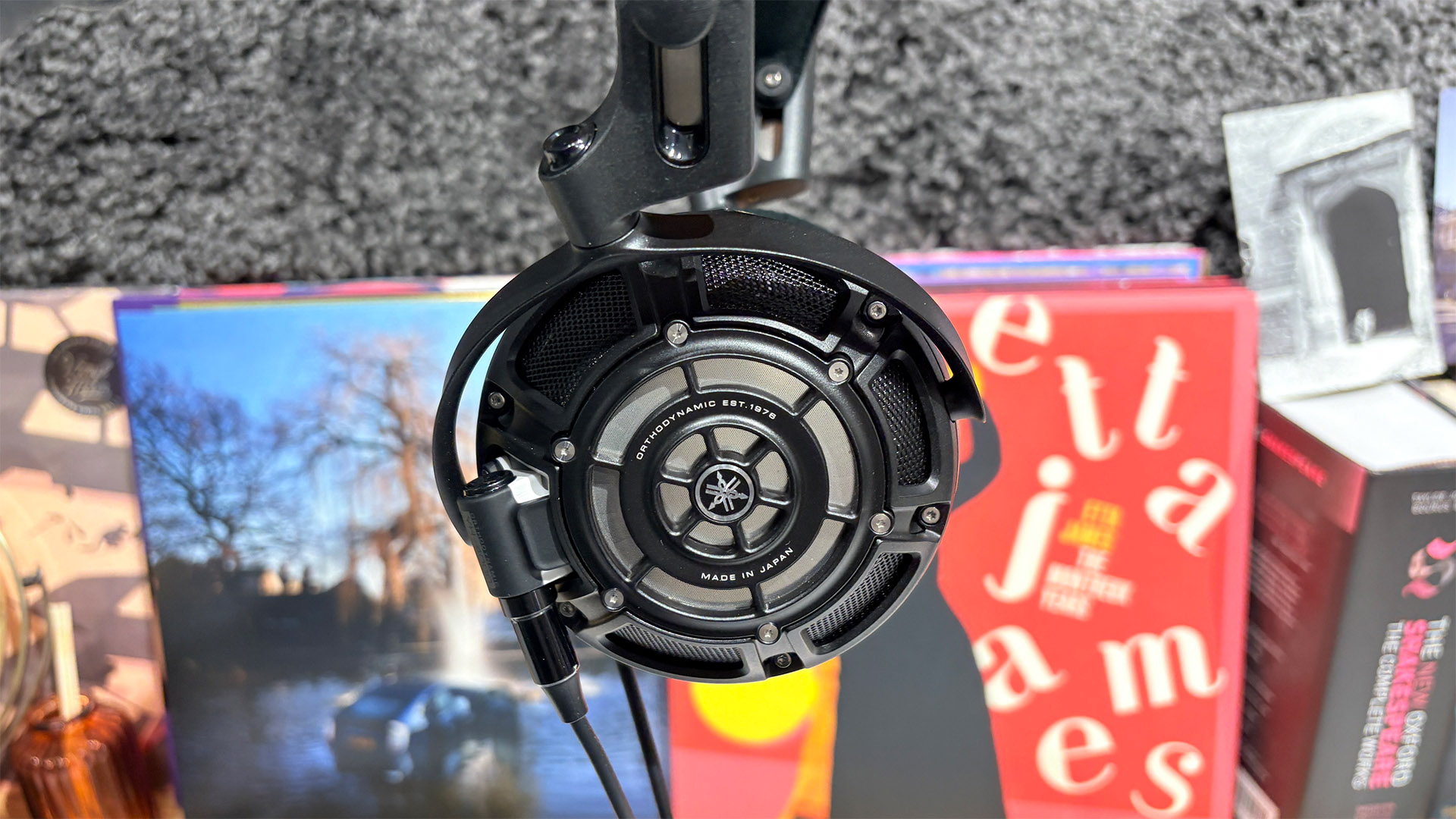 Yamaha YH-4000 open-back wired headphones showing outer earcup in front of busy bookshelf