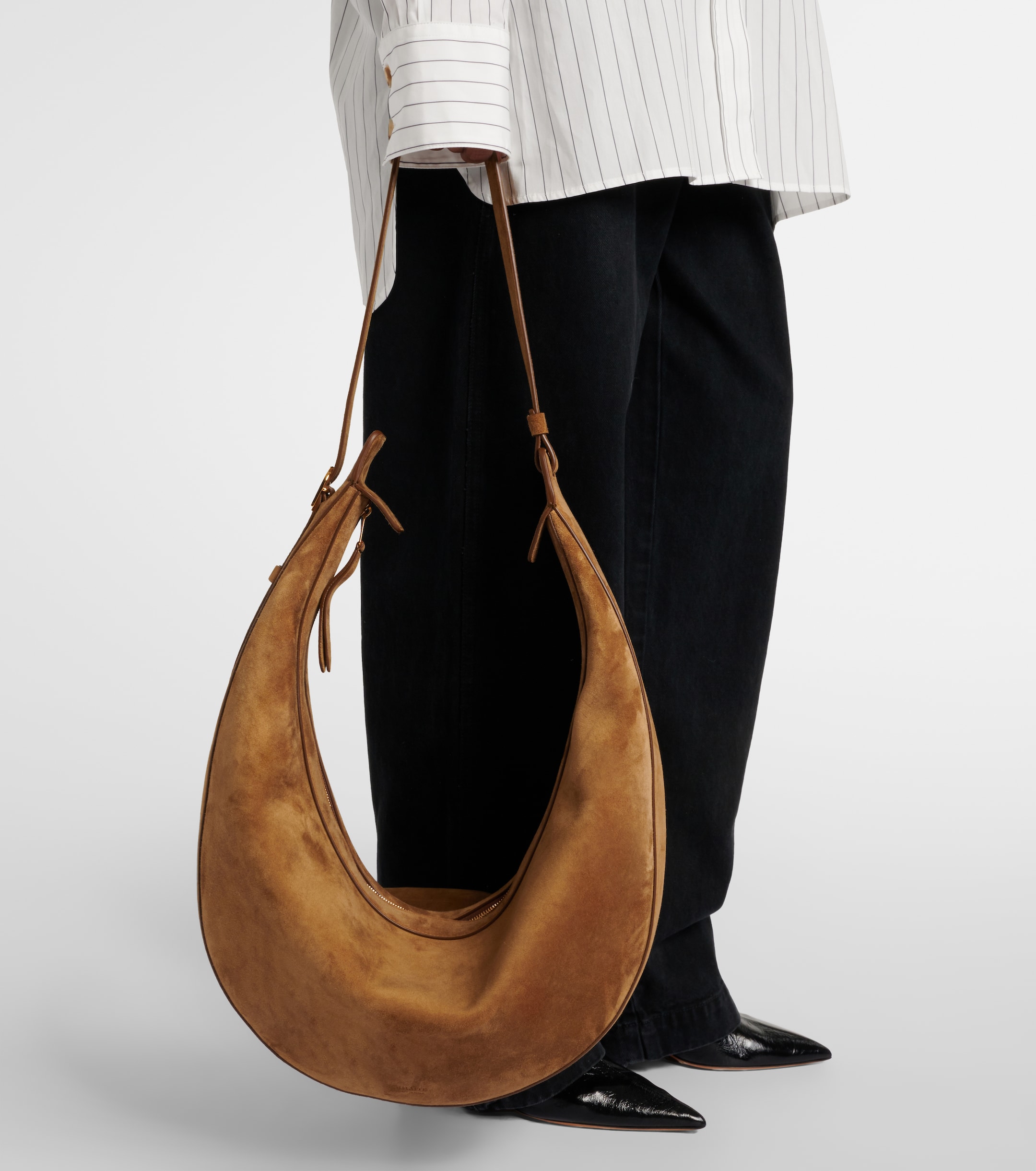 a model carrying a brown suede khaite bag