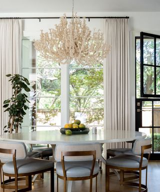 dining nook with round table, chandelier and floor to ceiling drapes