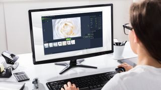 En kvinna sitter vid sin dator och använder Ashampoo Photo Optimizer 2019