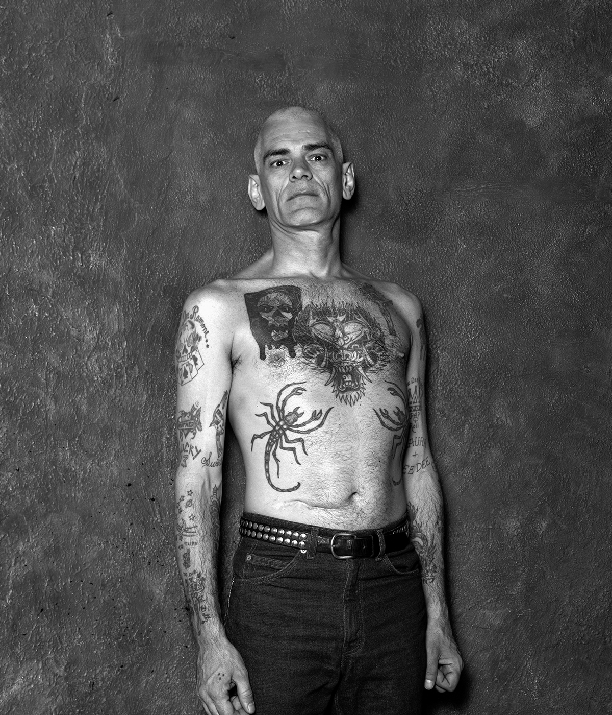 black and white portrait of Dee Dee Ramone with bare tattooed chest