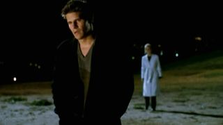 Sarah Michelle Gellar standing behind David Boreanaz in Buffy the Vampire Slayer.