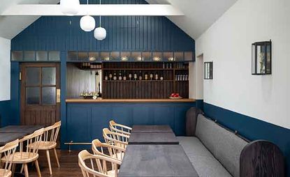 Kinneuchar Inn, Fife, UK with blue paneled walls, bench seating and wooden chairs