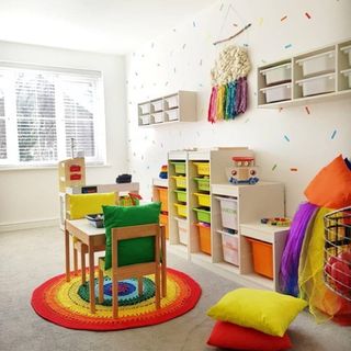 playroom makeover with wooden table and chair and multicolour cushions