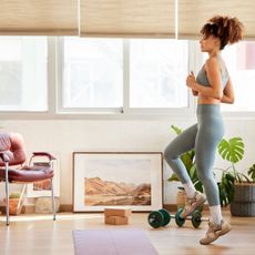 A woman doing an indoor step workout in her living room