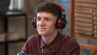 Jacob wearing red and black headphones producing the podcast in Abbott Elementary Season 5 "Trip"