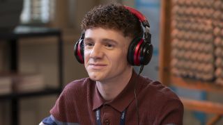 Jacob wearing red and black headphones producing the podcast in Abbott Elementary Season 5 "Trip"