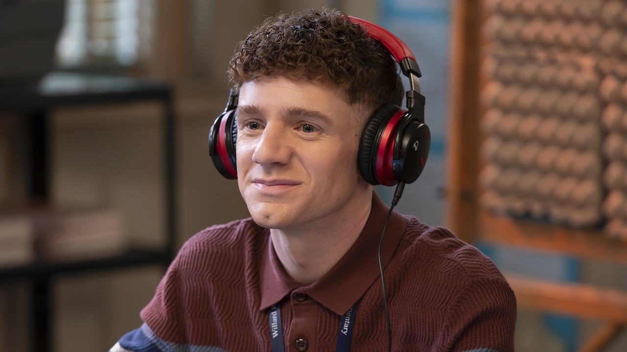 Jacob wearing red and black headphones producing the podcast in Abbott Elementary Season 5 "Trip"