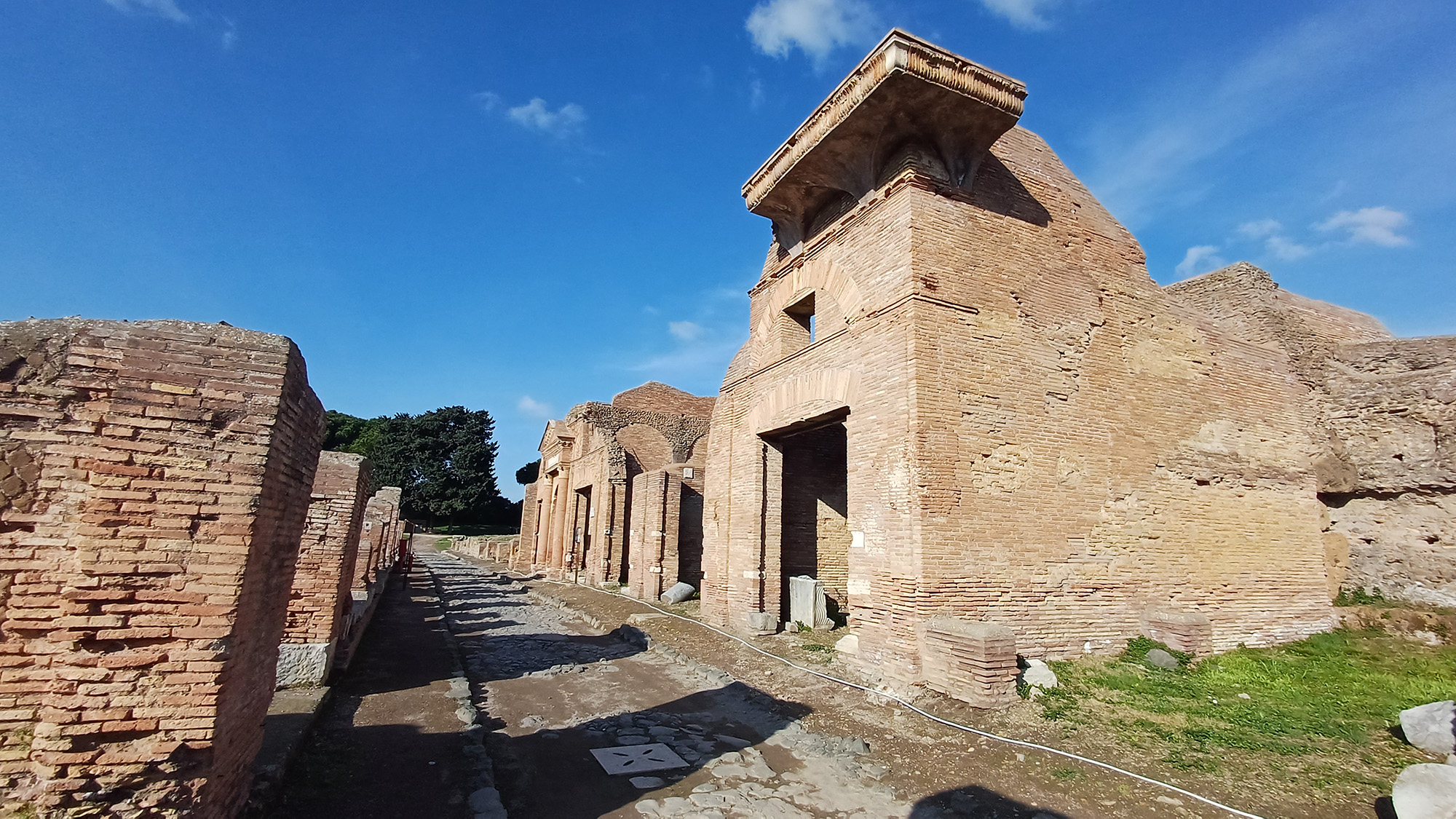 Ancient stone buildings sit next to a road.