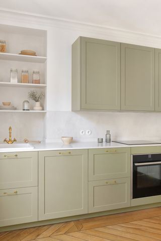 A kitchen with white countertop and light brown flooring