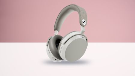 The Sennheiser Momentum 5 Wireless headphones on a white surface with a pink background